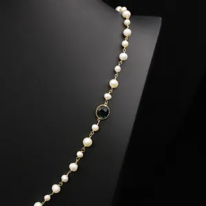 Elegante Süßwasserperlen Kette mit Goldkette und dunklem Edelstein Anhänger Detail.