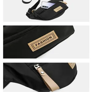 Nahaufnahme des schwarzen Brusttaschen-Details mit Reißverschluss, Label und praktischem Fach.