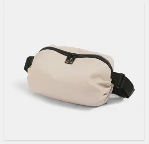 Minimalist nylon belt bag detail showing smooth beige fabric and sturdy black zippers.