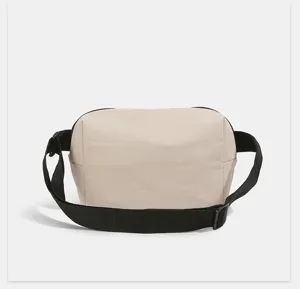 Minimalist beige nylon waist bag with black adjustable strap for women casual daily wear.