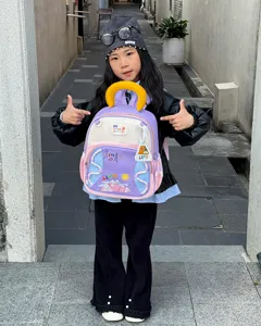 Detail du sac a dos pour enfants avec motifs de camping colores et poignee jaune vue proche.