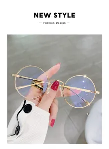 Primer plano de gafas redondas de metal dorado con filtro de luz azul, gran detalle.