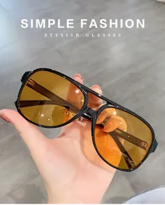 Vue de détail de lunettes de soleil rétro oversize double pont avec verres orange stylés.