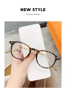 Vista detallada de gafas redondas vintage carey con finas patillas de metal dorado brillante.