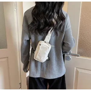 Casual white canvas chest bag worn cross-body, ideal for travel and daily sports styles.