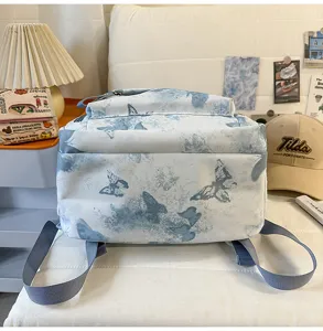 Detailaufnahme eines blauen Schmetterlings-Schülerrucksacks, die das Muster gut zeigt.
