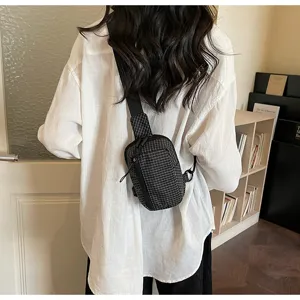 Detailed view of the plaid chest bag, trendy streetwear style, convenient crossbody wear.