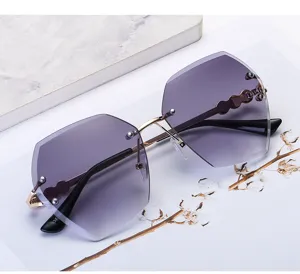Detail view of luxury rimless gradient purple sunglasses with elegant pearl accents and gold frame.