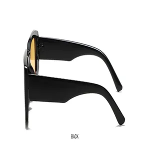 Side view detail of fashionable black thick-frame sunglasses with amber yellow lenses.