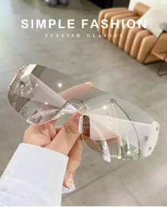 Dettaglio occhiali da sole scudo Y2K, grande lente monoblocco avvolgente per look alla moda.