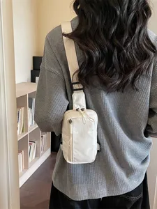 Stylish white canvas sling bag for women, perfect for outdoor travel and daily casual wear.