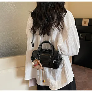 Black glossy PU leather women shoulder crossbody bag with cute plush horse pendant detail.