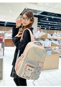 Detailed view of colorblocked school backpack with transparent front pocket and cute cat plush doll.
