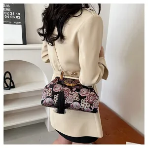 Detail der blumenbestickten Abendtasche mit Bambusgriff und eleganter schwarzer Quaste.