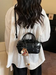 Stylish black glossy PU leather shoulder bag for women with cute horse pendant charm chic.
