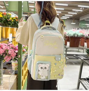 Cute color-block student backpack with clear window and plush cat doll for school daily use.
