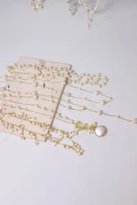Gedetailleerd overzicht van delicate natuurlijke parelkettingen met gouden kettingen en hangers.