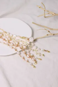 Nahaufnahme des mehrlagigen Naturperlenarmbands mit Golddraht, elegantes Accessoire.