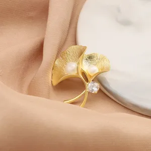 Elegant freshwater pearl ginkgo leaf brooch in matte gold finish, perfect suit accessory.