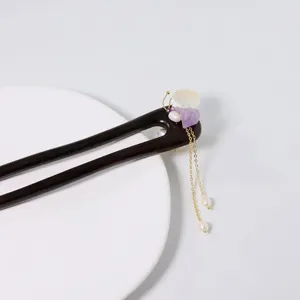 Vue rapprochée d'épingle à cheveux en bois vintage chinois avec pompon, perles et cristal élégant.