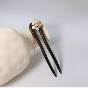 Vue détaillée du pic à cheveux en bois avec fleur de perle et chaîne, style traditionnel.
