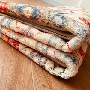 Close-up of Persian style printed area rug, detailed plush texture and stitched edge.