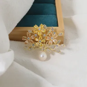 Elegant gold-plated flower bouquet brooch with sparkling cubic zirconia and drop pearl.