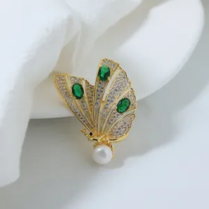 Elegant gold plated butterfly brooch with sparkling cubic zirconia, green stones and classic pearl.
