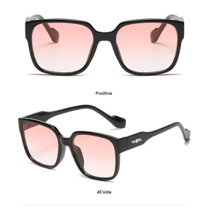 Vista detallada de gafas de sol negras cuadradas grandes con lentes degradadas rosadas.