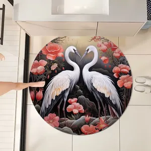 Détail de tapis de bain rond, avec un design élégant de grues blanches et de fleurs rouges.
