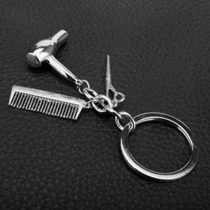 Llavero de metal plateado con dijes en miniatura de secador, peine y tijeras para estilistas.