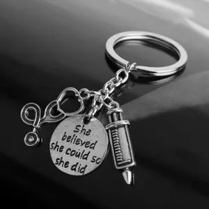 Medical theme keychain detail showing stethoscope, syringe and inspirational quote pendant