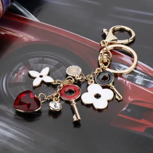Portachiavi quadrifoglio di lusso con cristallo cuore rosso e ciondolo fiore bianco per borsa.
