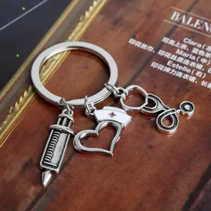 Close-up detail of medical keychain with nurse cap, syringe, and stethoscope charms.