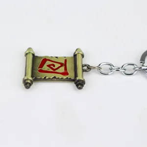Detailaufnahme des Metall-Schriftrollen-Schlüsselanhängers mit rotem Symbol und feiner Kette.