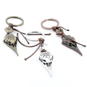 Detailed close-up of three retro Viking crow skull keychains with Nordic compass symbols.