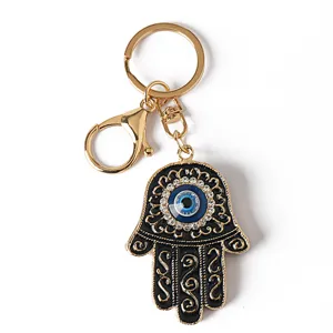 Detailed view of a Hamsa hand keychain featuring a blue evil eye charm and rhinestones.