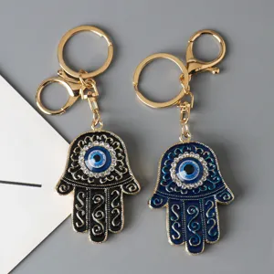 Detailed close-up of Hamsa Hand and Evil Eye keychains with decorative sparkling rhinestones