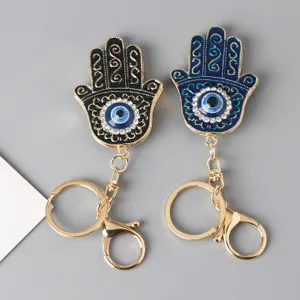 Macro view of blue and black Hamsa Hand keychains featuring Evil Eye and rhinestones