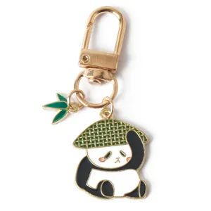 Detailed view of a cute enamel panda keychain with a green bamboo leaf charm and gold clasp.