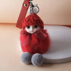 Detailed macro shot of red plush doll keychain with knit hat and ribbon bow decoration