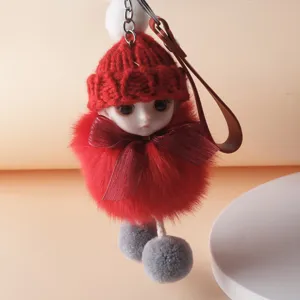 Detailed view of a cute red plush doll keychain with a knitted hat and fuzzy pom-poms