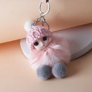 Detailed close-up of a cute plush doll keychain with pink knitted hat and soft faux fur body