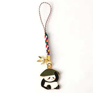 Detailed close-up of a cute panda pendant with a green hat and colorful braided strap charm.
