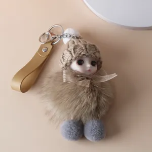Close-up of cute doll keychain with fluffy fur body and brown knitted hat accessory