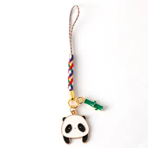 Close-up view of a cute panda keychain with bamboo charm and a colorful braided strap