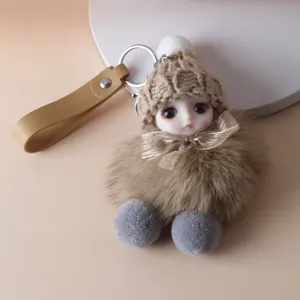 Detailed macro view of a cute plush doll keychain charm with brown fur and knit hat.