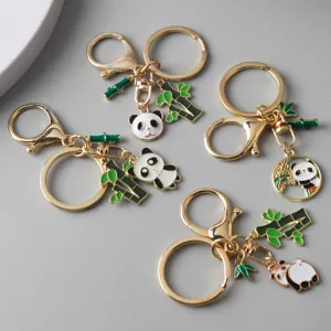 Detailed view of four cute panda keychains with green bamboo charms on gray background.