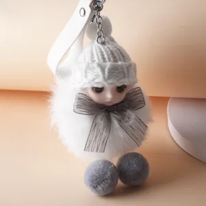 Macro detail of a cute plush doll keychain with a white knitted hat and mesh bow