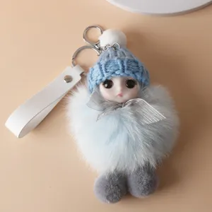 Close-up of a cute light blue plush doll keychain with a knit hat and fur ball body